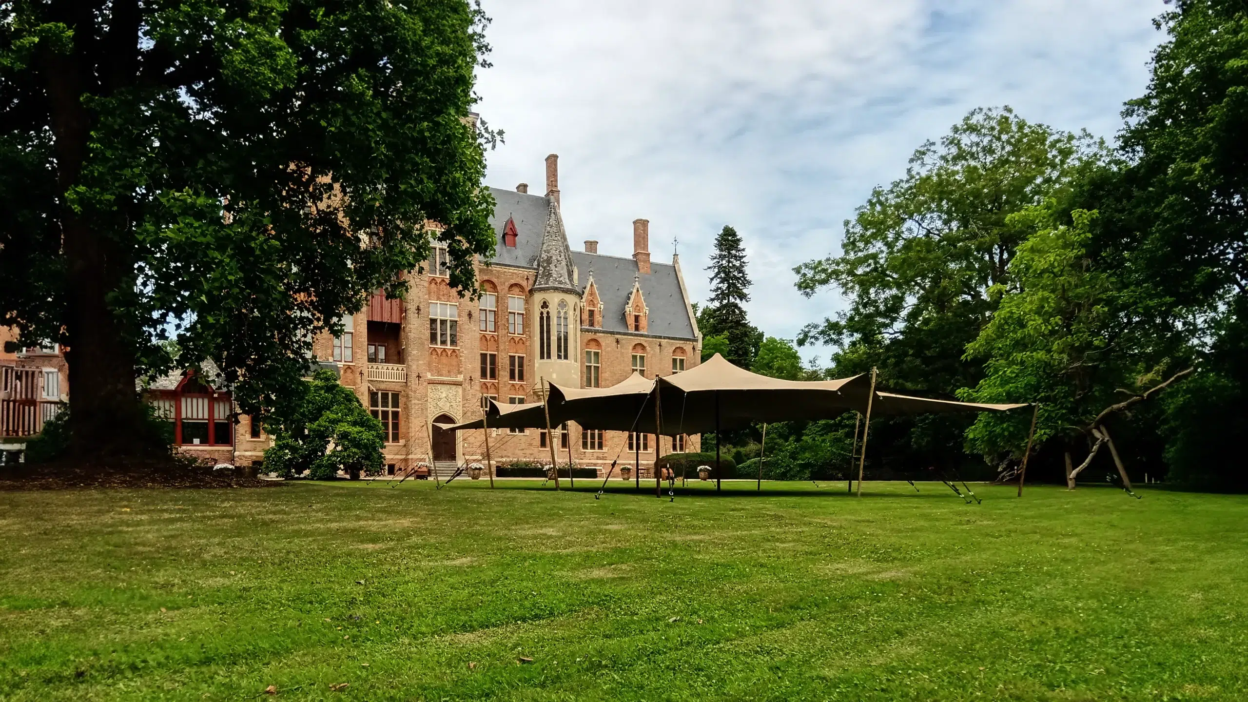 Qtents feszített sátor a kastély előtt egy zöld mezőn